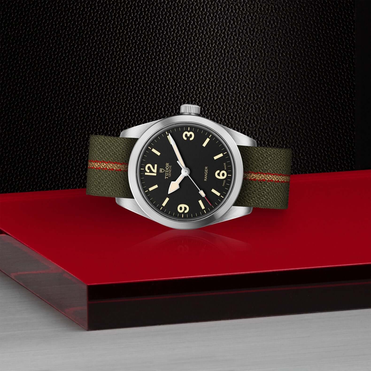 Wristwatch with green strap on a red and black background
Tudor Ranger M79930-0003 Bandiera Jewellers
