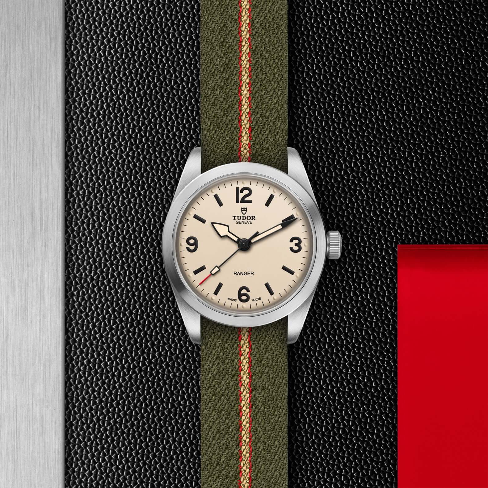 Watch with a green strap on a textured black and red background
Tudor Ranger M79930-0008 Bandiera Jewellers