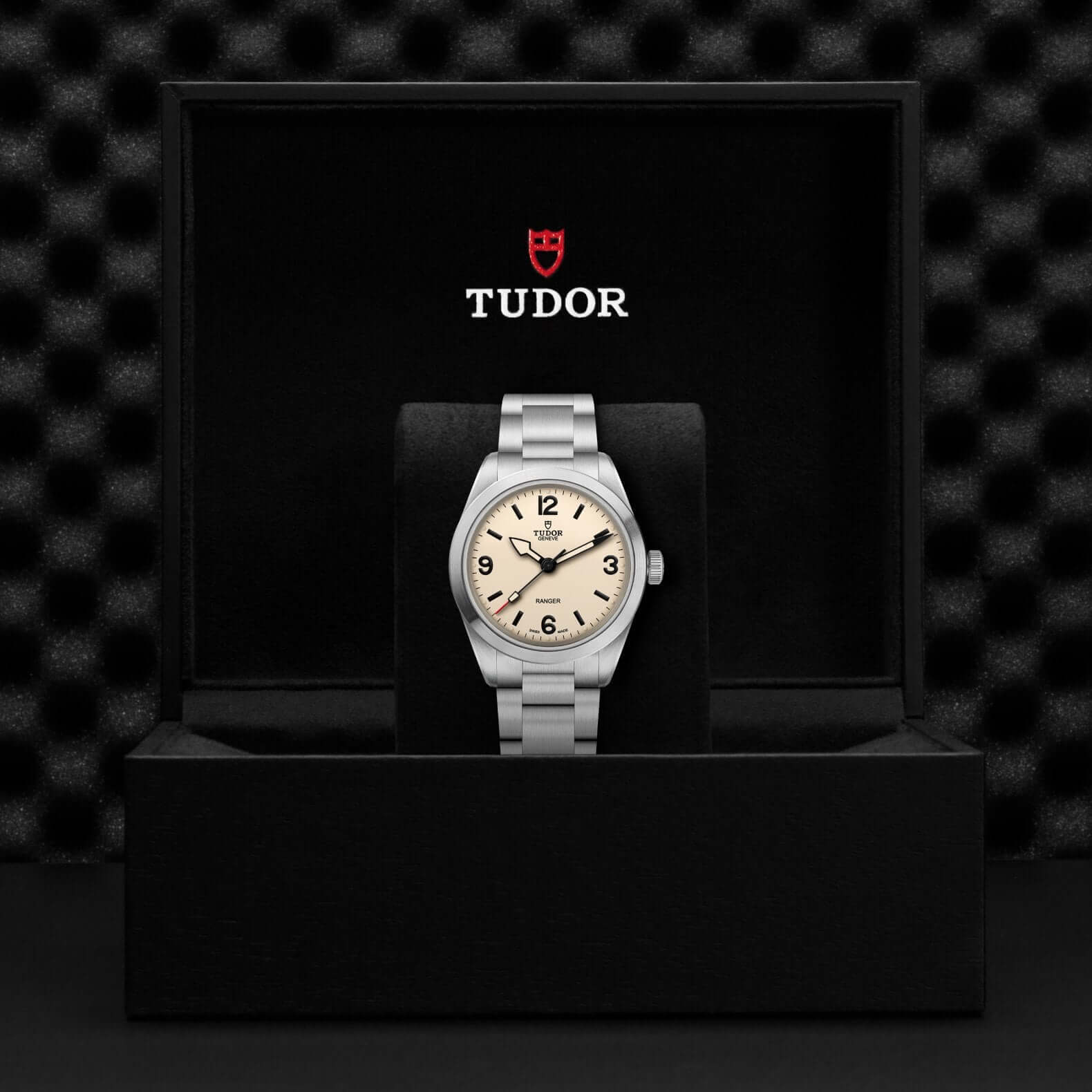 Tudor watch in a black box with the Tudor logo on a dark textured background
Tudor Ranger M79950-0008 Bandiera Jewellers