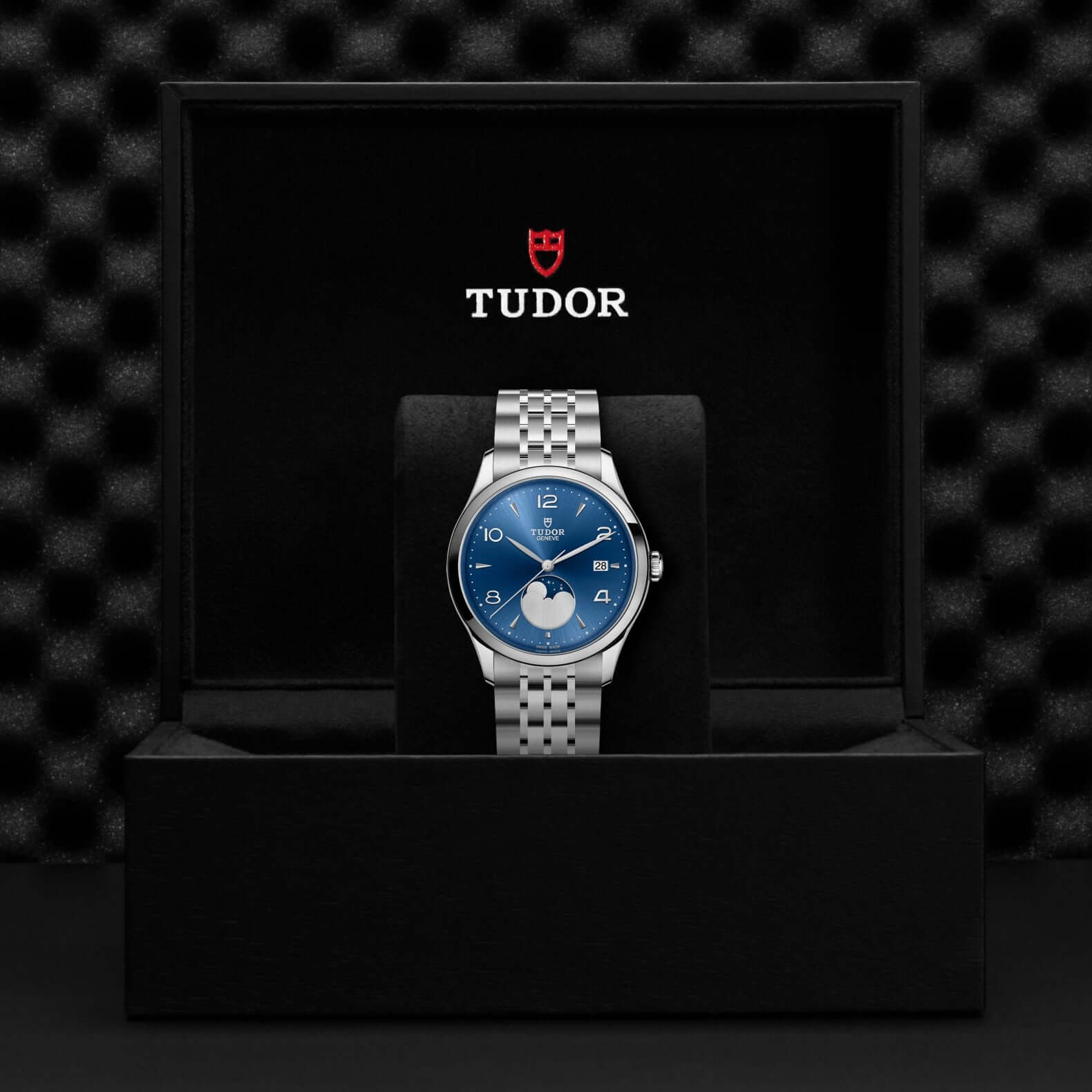Tudor watch with blue face and silver bracelet in a black box with Tudor logo.
Tudor 1926 Luna M91560-0002 Bandiera Jewellers