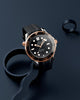 Luxury watch with black dial and rose gold case on a dark background