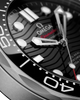Close-up of an Omega Seamaster Submariner watch dial and bezel, showing a black patterned dial with silver hour markers, silver hands, and a black rotating bezel with white markings.