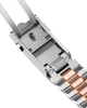 Close-up of a watch strap with silver and rose gold colors on a white background