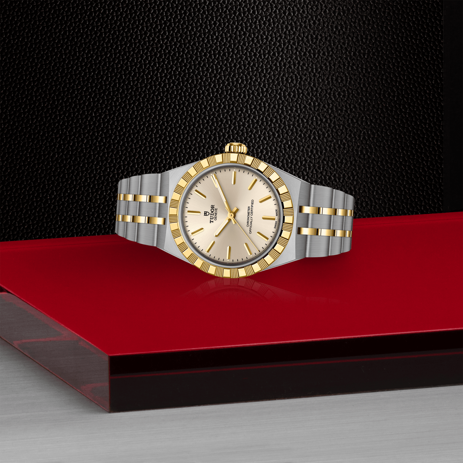 Two-tone watch with silver and gold accents on a red platform against a black background
Tudor Royal 30mm M2830A1A3-0003 Bandiera Jewellers